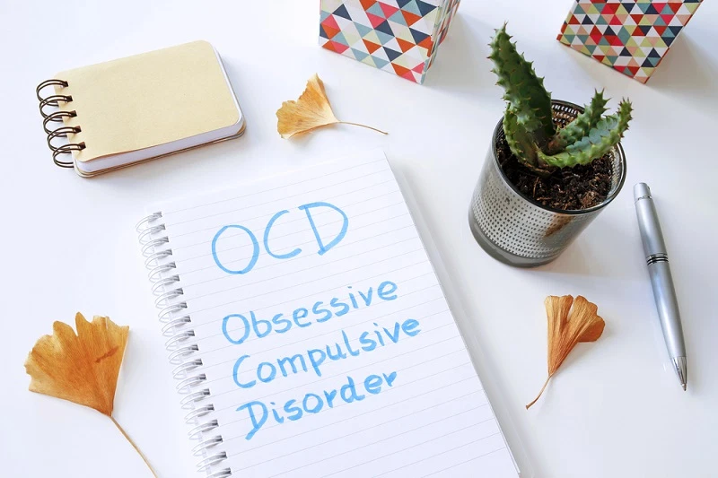 OCD Obsessive Compulsive Disorder written in notebook on white t