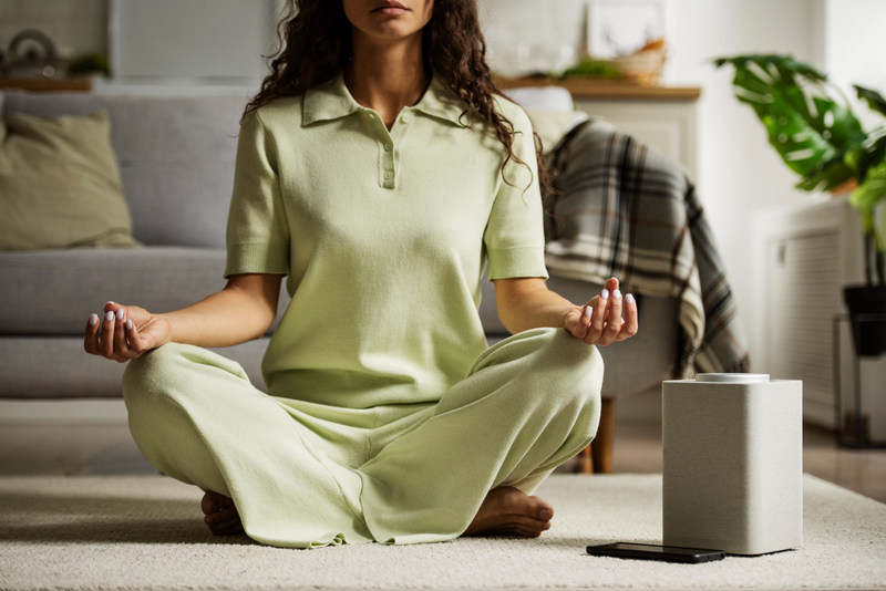 front view woman meditating with smart speaker