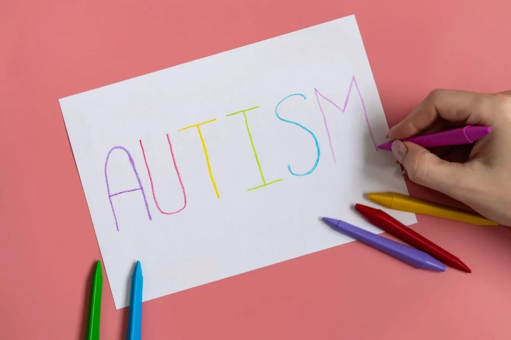 text word autism on paper sheet written by colorful letter on blue background