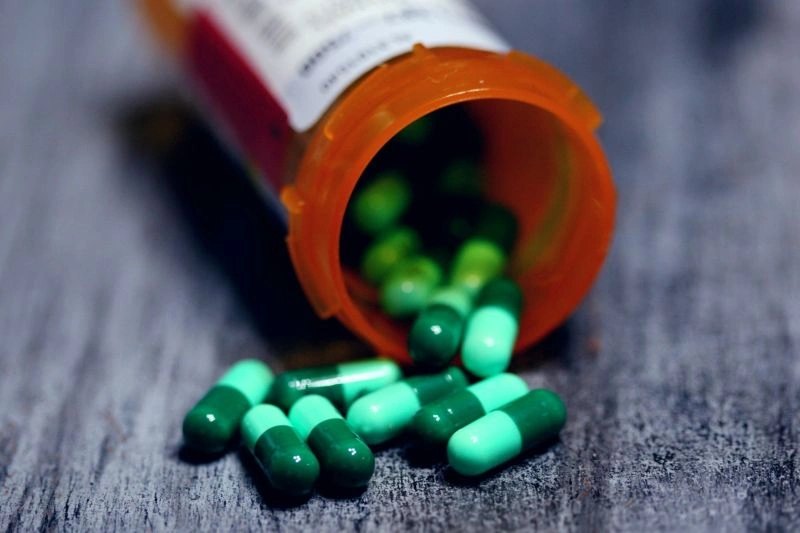 Capsules spilled from a prescription bottle onto a surface, representing treatment adjustment issues and the question of can an antidepressant stop working for some patients.