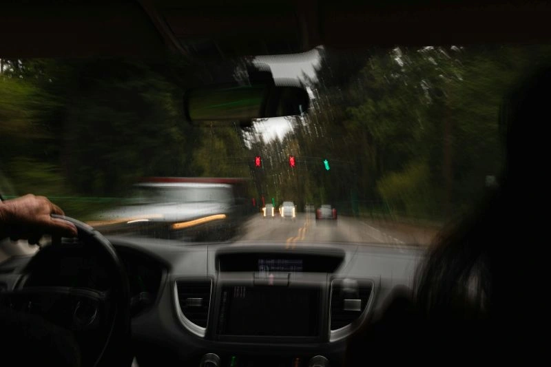 Can you drive after TMS sessions? A view from inside a moving car showing a driver on the road.