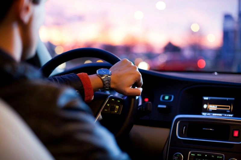 Can you drive after TMS treatment safely? A person driving a car in the evening with hands on the steering wheel.