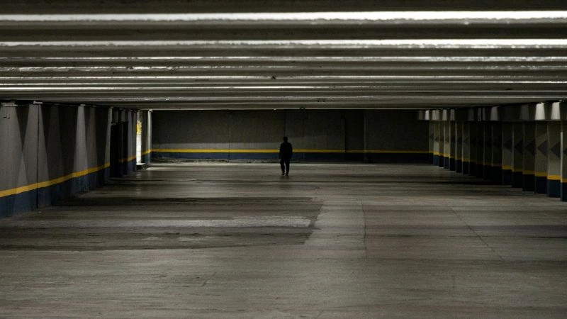 Nocturnal anxiety represented by a person walking alone in a dark, empty space, reflecting nighttime fear and isolation.