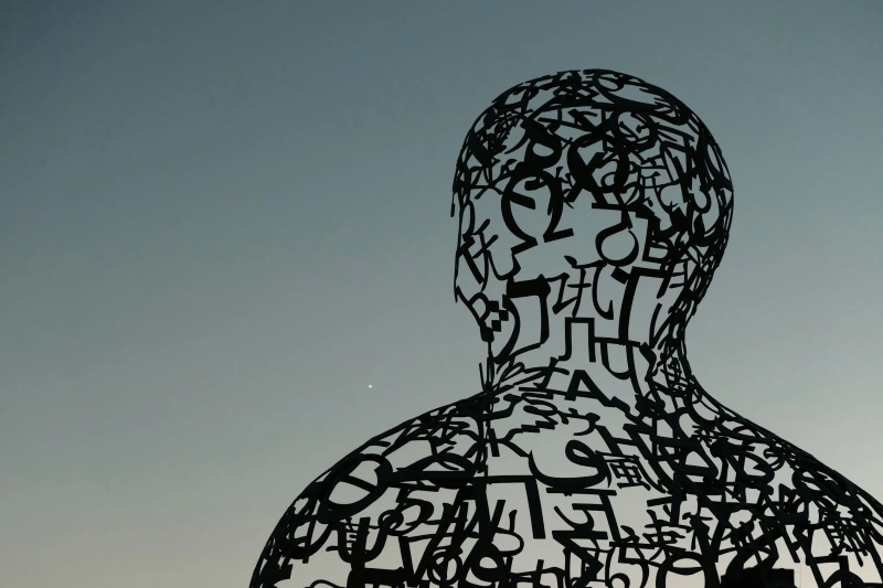 Abstract human figure filled with overlapping symbols, representing intrusive thoughts, uncertainty, and confusion associated with false memory OCD.